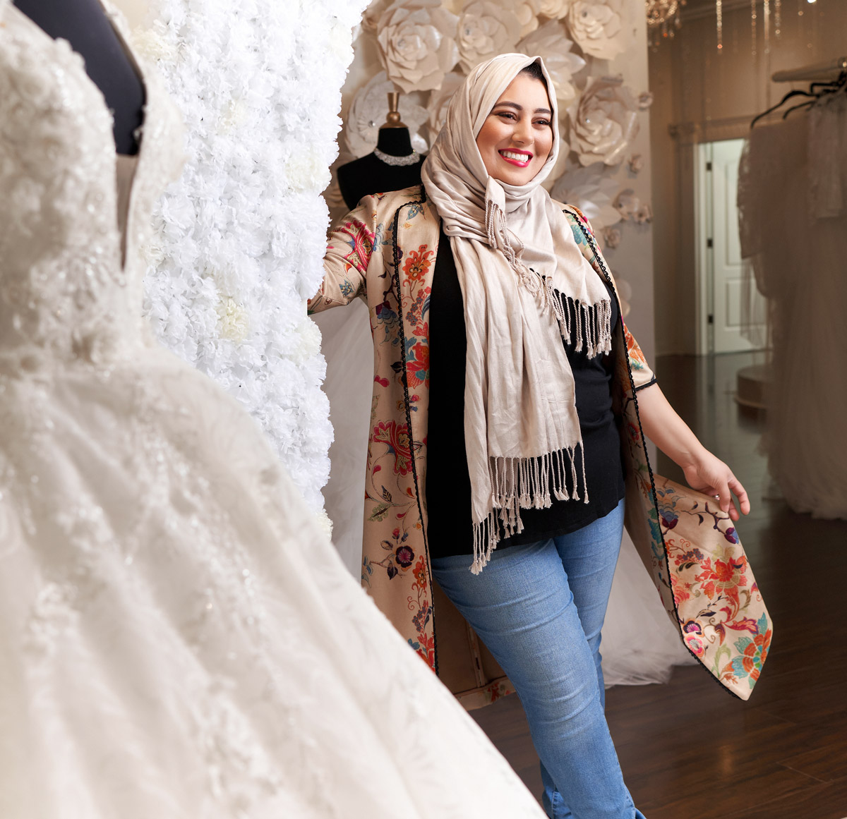 Rawan Asad standing next to a wedding gown