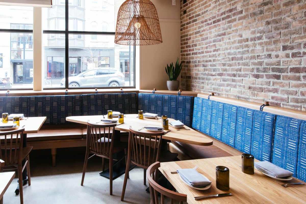 A dining room with a long wooden banquette