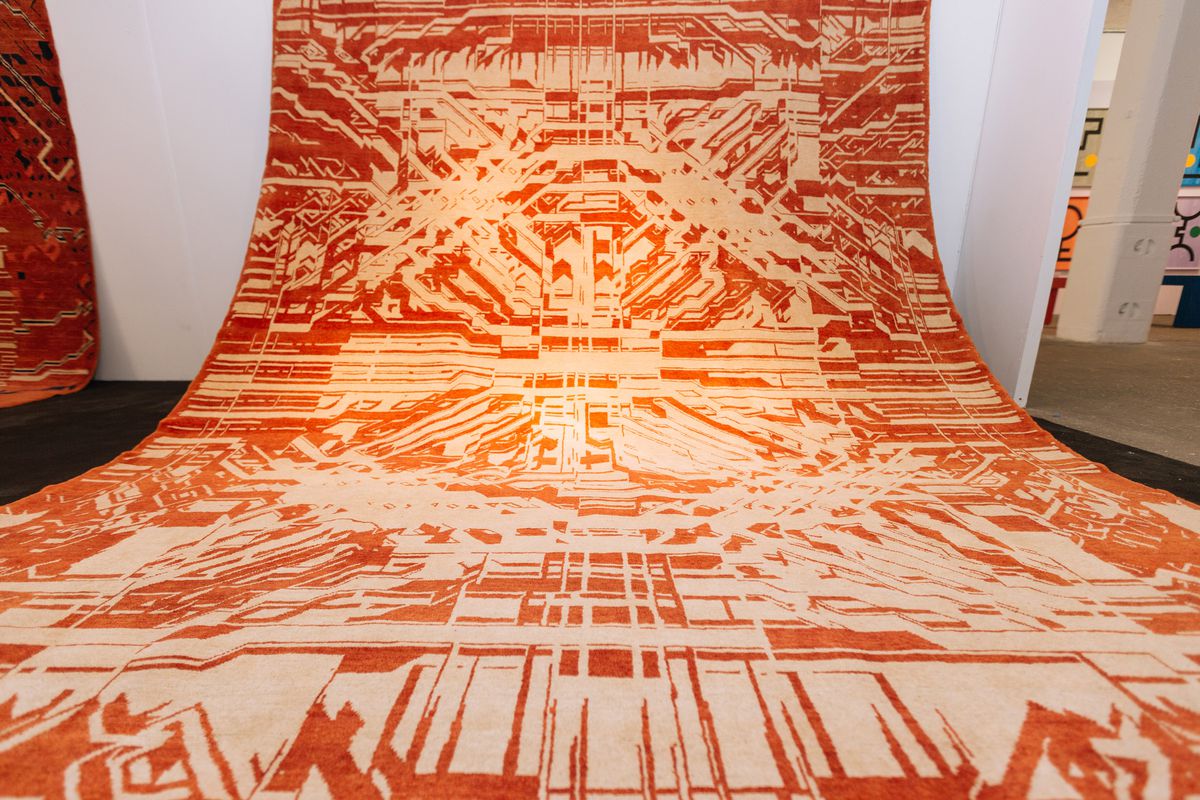 Orange and white patterned rug on display.